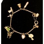 A 9ct gold charm bracelet with charms, weighing approx 17.