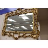 A gilt metal framed wall mirror, together with a plaster gilded mirror,