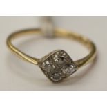 An 18ct gold and platinum four stone diamond ring set in an off set square detail,