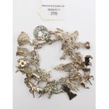 A white metal charm bracelet with numerous Continental charms, 4.