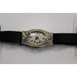 A white metal and diamond ladies cocktail watch, the case front set with eight faceted diamonds,
