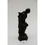 A small bronze figurine of a semi nude girl, seated on rocks,