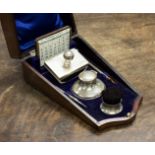 A boxed silver writing set comprising of brush pen cleaner, capstain inkwell blotter,