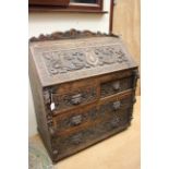 A Victorian oak carved bureau, in the Renaissance Revival style,
