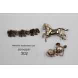 Three silver brooches, a horse,