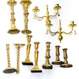 A box containing a collection of brass candlesticks,