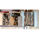 A metal tool box containing a collection of assorted tools, including pliers, screw drivers,