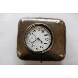 A travelling white metal pocket watch of large proportions in silver cased easel stand,