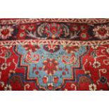 Pair of Persian woollen carpets, floral design on red ground,