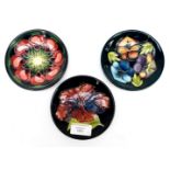 Three Moorcroft circular pin dishes, including one Hibiscus, April Tulip plus a collectors day dish,