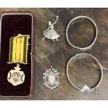 Two silver bangles, a silver medallion and a silver ballerina brooch, together with R.A.O.B.
