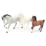 A matte white Royal Doulton horse, a matte grey horse, dapples and black mane and tail, Beswick,