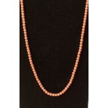 A polished pink coral bead necklace