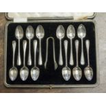 A boxed set of twelve silver teaspoons with sugar tongs, Sheffield 1924,
