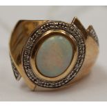 A 9ct gold ring set with an oval opal surround by small diamond chips in white gold, size T,
