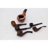 A collection of various tobacco pipes, with burr wood terminals and black mouth pieces,