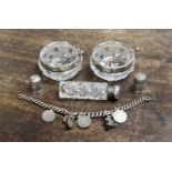 Two silver thimbles, a silver charm bracelet, a silver capped perfume bottle,