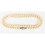 A string of pearls with a white metal clasp,