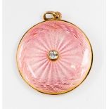 A diamond set pink guilloche enamelled gold pendant with glazed keep sake compartment to reverse