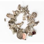 A silver charm bracelet containing assorted silver and white metal charms