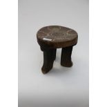 A tribal wooden triple leg stool inset with coloured beads