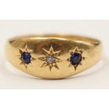 An eighteen carat gold ring star set with two blue stones either side of a diamond,
