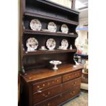 A George III oak dresser and rack, the rack with three plate shelves, scalloped edges,