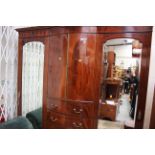 An Edwardian mahogany triple sectioned wardrobe, in the manner of Thomas Sheraton,