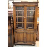 An early 20th Century oak bookcase, the upper section with two glazed doors,