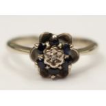 A 9ct white gold ring set with six sapphires in a flower design,