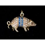 A Victorian sapphire, seed pearl and garnet yellow metal pig charm,