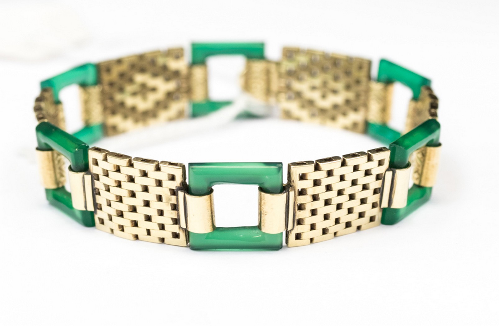 A yellow metal brick link bracelet with alternate green square cut out links,