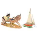 A Beswick model of a small yacht and a man pushing a donkey,