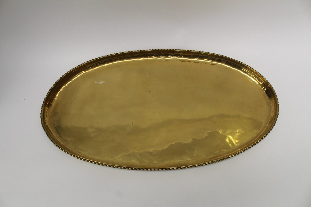 Hugh Wallis, an Arts and Crafts brass oval tray with rope twist border, stamped march,