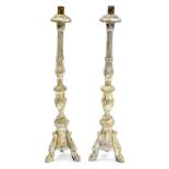 A pair of carved wood and Gesso Spanish style candlesticks, distressed with silvered paint,