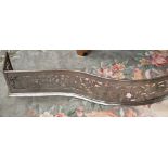 An 18th or 19th century fretted steel fire guard, serpentine form with foliate and zoomorchic band,