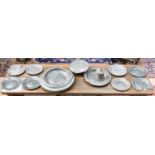 A collection of pewter items including plates and chargers, together with a footed platter,