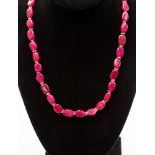 A ruby necklace of polished irregular beads with yellow metal spacers,