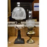 Two oil lamps with glass, decorated, shades and glass funnels, one brass base,