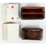 A leather tooled card case with two packs of cards