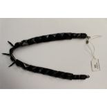 A Whitby Jet necklace with graduated facetted beads and three claw like beads to front lower end,