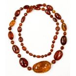 A faceted amber type graduated bead necklace with oval and round shape beads ranging in size from