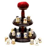 A Royal Crown Derby collection of fifteen thimbles, all in different pattern, complete with stand,