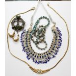 Five items of costume jewellery to include a blue topaz style stone gold plated necklace,