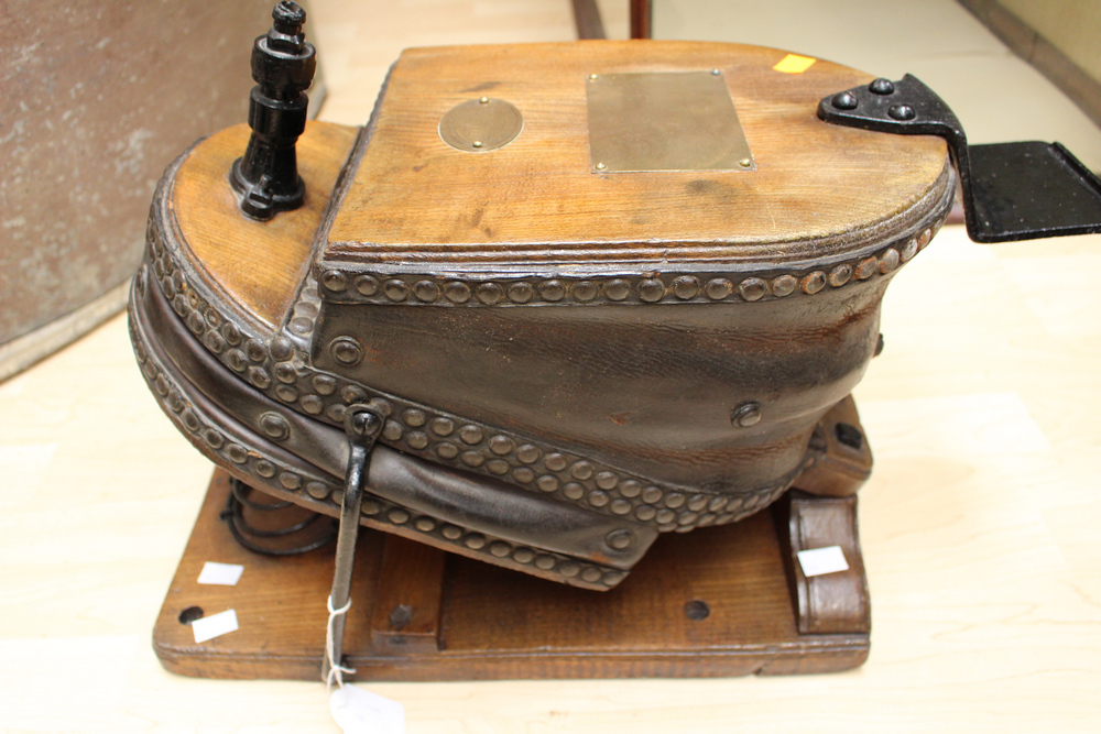 An early 20th Century leather foot bellow raised on an elm base . Serial no 11961.