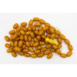 A bag of loose butterscotch amber type beads each bead measuring approx 23mm x 13mm with a weight