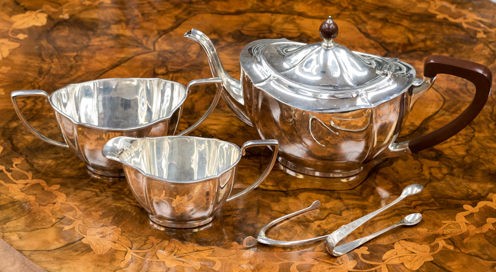 A George V silver three piece tea service to include teapot with Bakelite handle and finial,