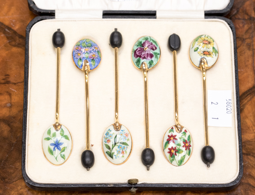 A set of six gilt and enamel coffee spoons, with bean finials, each enamelled a different flower,