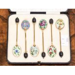 A set of six gilt and enamel coffee spoons, with bean finials, each enamelled a different flower,