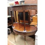 A pair of George III style carved mahogany demi lune console tables,